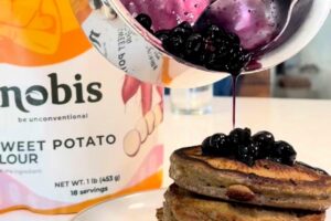 Blueberry lemon maple sauce poured over a stack of nobis sweet potato flour pancakes